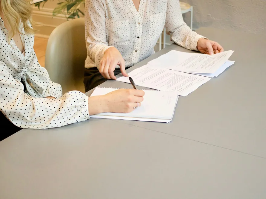 Deux personnes parcourent des documents à une table pendant un rendez-vous