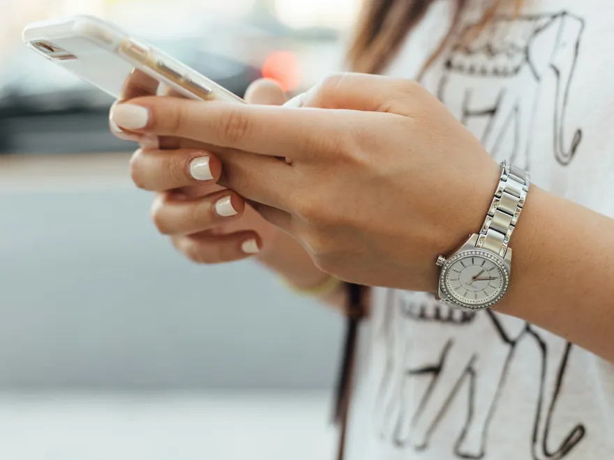 Mains tenant un téléphone, dans la rue